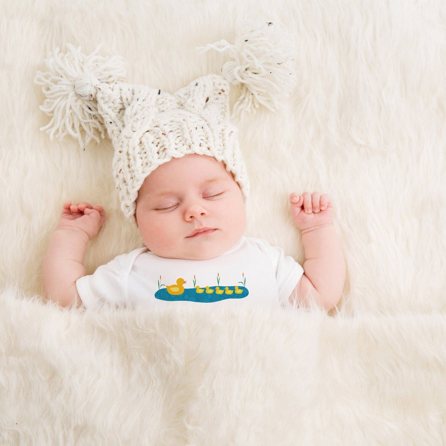 5 Little Ducks Baby Grow 1 Baby lying on a fluffy blanket wearing the 5 Little Ducks Baby Grow